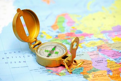Ein Kompass liegt auf einer Weltkarte.